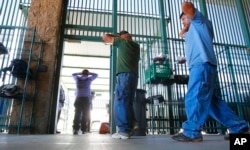 2012年8月9日,在亚利桑那州图森的美国海关和边境保护部门,非法移民的嫌疑人等待处理。