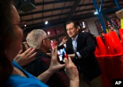 共和党总统参选人克鲁兹参议员3月25日在威斯康辛州欧斯克许市的一次竞选活动讲话前,向支持者致意。