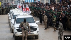 2025 年 2 月 22 日,以色列和哈马斯交换人质和囚犯现场。图为:国际红十字会 (ICRC) 的车辆抵达加沙地带中部的努塞拉特,接收以色列人质。走在车队前面的是一名哈马斯的武装分子。