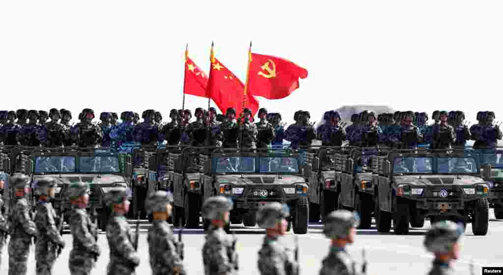 中国解放军军人在内蒙古朱日和训练基地参加阅兵,庆祝解放军建军90周年。中共党旗在前,国旗居中,军旗在后(2017年7月30日)。这引起争议,因为中华人民共和国国旗法第十五条第二款规定:“列队举持国旗和其他旗帜行进时,国旗应当在其他旗帜之前。”