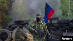 亲俄罗斯的分离主义分子在斯洛文斯克附近的检查站站岗