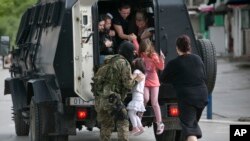 Cossacks help a boy to take a bath in the icy waters of a lake during the celebration of the Epiphany holiday near the village of Leninskoe, some 15 km of Bishkek, Kyrgyzstan.