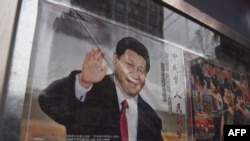 在北京街道旁玻璃窗宣传栏里展示的中国国家主席习近平的宣传画(2018年2月28日)。