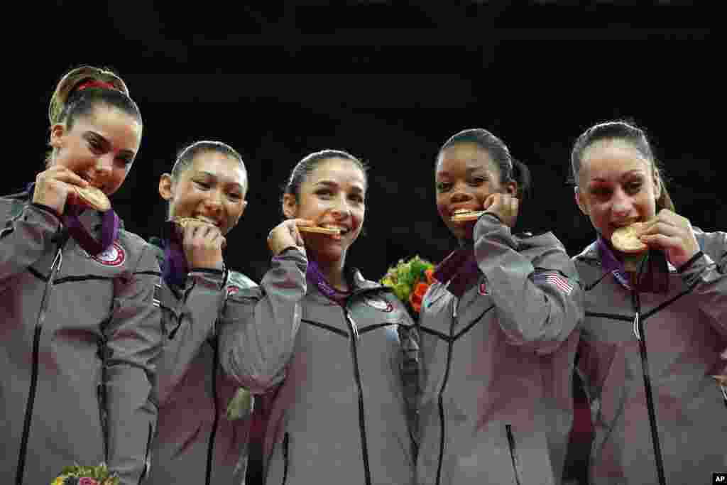 (Từ trái qua) Vận động viên McKayla Maroney, Kyla Ross, Alexandra Raisman, Gabrielle Douglas và Jordyn Wieber cắn vào huy chương vàng sau trận chung kết thể dục nghệ thuật nữ tại Olympic London 2012, 31 tháng 7, 20