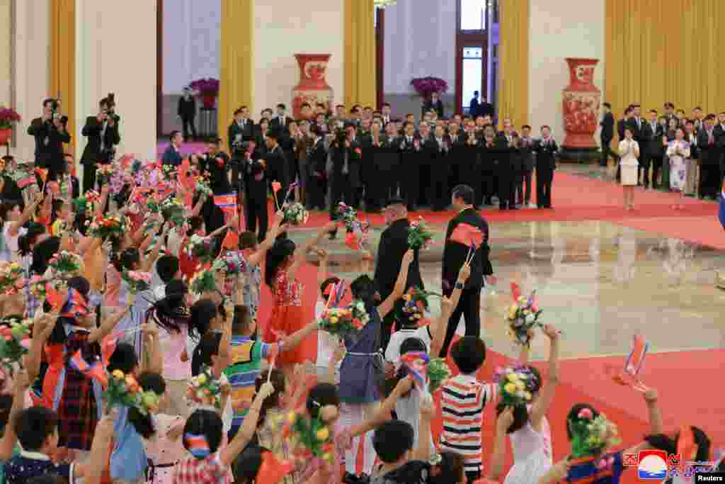 2018年6月19日,北京人民大会堂的欢迎仪式中,儿童迎接中国国家主席习近平和朝鲜领导人金正恩。在川普总统威胁要对价值2千亿美元的中国产品征收关税后不久,北京宣布了金正恩访华的消息。与以往不同的是,中国这次是在金正恩访问一开始而不是在他访问结束后才发布消息。