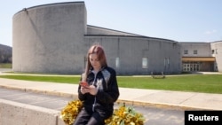 资料照片:布兰迪·利维坐在她就读的宾夕法尼亚州的高中外。她几年前因对啦啦队不满而在社交媒体骂脏话并被啦啦队暂停资格的争议因涉及言论自由权,目前成为美国最高法院将要裁决的大案。