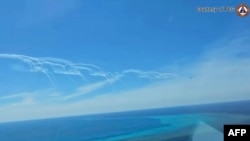 菲律宾海岸防卫队(PCG) 分发影片的荧幕截图显示,2024 年8 月19日,一架中国空军战斗机在菲律宾渔业和水产资源局飞机附近施放照明弹。