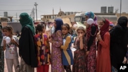 妇女和儿童在伊拉克的一个难民营排队领取食物(资料照)