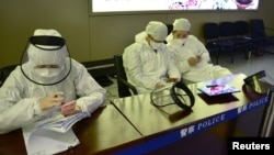 中国黑龙江省哈尔滨机场的公安人员身穿防护服进行旅客登记。(2020年4月11日)