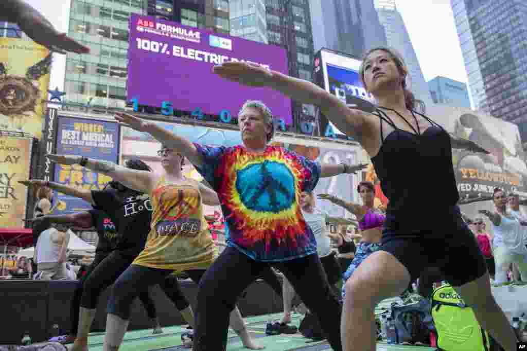 2018年6月21日,在有名的纽约时报广场上,人们集体操练瑜伽。