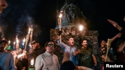 2017年8月11日,在维吉尼亚州夏洛茨维尔举行的团结右翼集会之前,白人民族主义者参加了维吉尼亚大学的火炬点火游行。