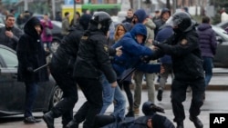 在明斯克的反对派集会中,一名被白俄罗斯警察扑倒在地的妇女试图自卫(2017年3月25日)
