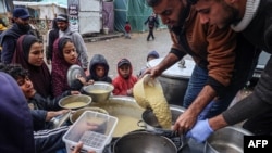 资料照片：志愿者向加沙地带南部拉法的流离失所的巴勒斯坦人分发食物。（2024年2月18日）