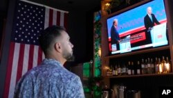 Seorang pengunjung menyaksikan debat antara Presiden Joe Biden dan kandidat presiden dari Partai Republik, mantan Presiden Donald Trump, pada Kamis, 27 Juni 2024, di Scottsdale, Arizona. (Foto: AP)