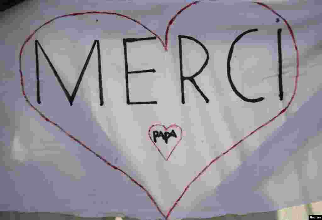Hàng chữ viết bằng tiếng Pháp "Cám ơn Đức Giáo Hoàng" tại Quảng trường Thánh Phêrô, ngày 27/2/2013.