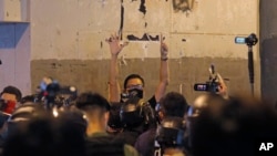 资料照:前香港民主派立法会议员林卓廷(中)在纪念元朗地铁袭击事件一周年的新闻发布会上被防暴警察包围,他用五个手指表达“五项诉求,一个都不能少”的抗议诉求。 (2020年7月21日)