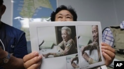 韩国女士申筠顺举着曾境被迫充当日军慰安妇的92岁母亲白奉礼的照片,在首尔的家中接受采访。(2020年7月29日)