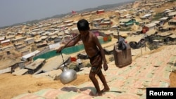 一名罗兴亚男孩在孟加拉国的一个罗兴亚人难民营里挑水。(2018年3月22日)