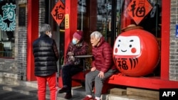 几位老人在北京一家餐馆外聊天。(2023年3月16日)