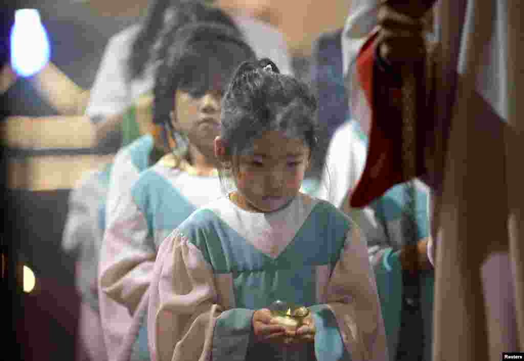 2018年9月29日,在北京的一个政府认可的天主教堂“南堂”举行的周末弥撒中,女孩儿手捧蜡烛。 天主教教宗方济各9月26日在写给中国教徒的信中说,中国信众应该做“好公民”,但在维护人的尊严的时候也要不吝“提出批评”。