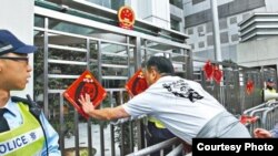 香港人权团体抗议后在中联办外贴挥春(苹果日报图片 )