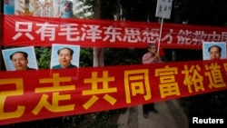 资料照:中国毛派人士手举毛泽东画像和标语横幅在广州南方周末报社外举行抗议集会。(2013年1月9日)