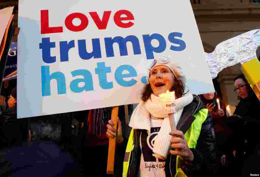 A woman holds a sign and a candle as she takes part in the women's rights event "Lights for Rights," a protest against the inauguration of Donald Trump as new U.S. president, in front of the Theatre Royal de la Monnaie in Brussels, Belgium, Jan. 20, 2017.