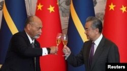 中国外交部长王毅2024年1月24日在北京同瑙鲁外长莱昂纳尔·安格明(Lionel Aingimea)举行会谈并签署恢复外交关系的联合公报后碰杯庆贺。(媒体联访照片)