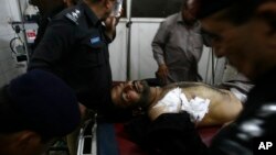 Sĩ quan cảnh sát Pakistan bên cạnh một đồng nghiệp bị thương tại một bệnh viện địa phương ở Peshawar, Pakistan, ngày 10/4/2013.