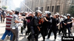 2013年 8月13日,在埃及首都开罗举行的示威冲突中,警察拘禁被推翻的伊斯兰主义总统穆尔西的支持者。