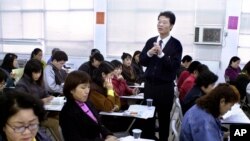 资料照:台北一名社会工作者向居住在台湾来自中国大陆的妇女介绍台湾当地的法律、教育及其在台湾的权利。(2003年3月5日)