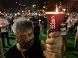 参与六四31周年维园烛光集会的市民高举烛光，为六四屠城死难者默哀一分钟 （美国之音/汤惠芸）