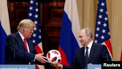 美国总统川普2018年7月16日在芬兰赫尔辛基同俄罗斯总统普京会晤后举行联合新闻发布会,在会上接受了普京送给他的足球。