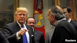 美国总统川普主持美国汽车业执行执行官会议时和菲亚特克莱斯勒首席执行官马尔乔内交谈。(2017年1月24日)