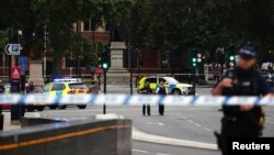 在伦敦发生一名男子驾车撞人事件后,武装警察在英国议会大厦外站岗(2018年8月14日)