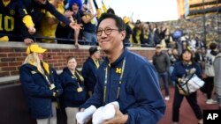 资料照片:在密歇根州安娜堡,在全国大学体育协会(NCAA)大学美式橄榄球赛季密歇根对阵俄勒冈的一次比赛期间,密歇根大学校长小野三太准备向观赛人群抛掷T恤衫。(2024年11月2日)