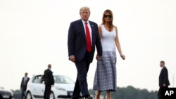 特朗普总统和第一夫人梅拉妮亚在法国比亚里茨七国集团峰会结束后走向“空军一号”专机,启程返美。(2019年8月27日)