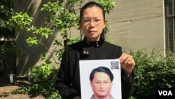 遭中国拘禁台湾人权工作者李明哲之妻李净瑜抱着李明哲像 (2017年5月17日,美国之音钟辰芳拍摄)