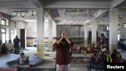 在加德满都,一名藏族妇女在同情西藏的暴力受害者和自焚抗议者的活动中祈祷