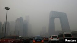 Xe cộ lưu thông trên đường phố trong khói mù dày đặc tại Bắc Kinh.