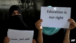 Anak-anak perempuan Afghanistan menunjukkan poster dalam protes ilegal untuk menuntut hak atas pendidikan, di sebuah rumah pribadi di Kabul, Afghanistan, 2 Agustus 2022. (Foto: Ebrahim Noroozi/AP Photo)