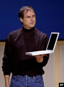 2001年5月,乔布斯在苹果公司总部新闻发布会上展示新款iBook手提电脑