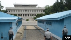 Ba người lính Nam Hàn đứng nhìn sang tòa nhà Panmungak của Bắc Hàn