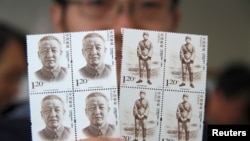 资料照片:有人手持中国前副总理习仲勋的纪念邮票。习仲勋是中国领导人习近平的父亲。(2013年10月15日)