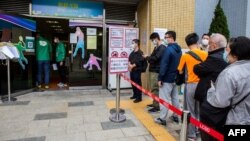 香港市民在九龙湾一个街区排队打中国科兴生物生产的新冠疫苗。(2021年2月26日)