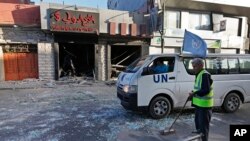 Công nhân Palestine quét dọn các mảnh vỡ trên đường phố ở thành phố Gaza, ngày 17/7/2014.