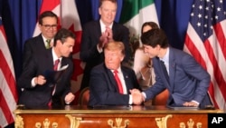 美国总统特朗普(中),加拿大总理特鲁多(右)和墨西哥总统涅托(左)签署了《美墨加协议》,取代了1994年生效的《北美自由贸易协定》。(2018年11月30日)
