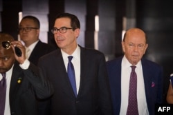 2018年5月4日,美国财政部长史蒂文·努钦(左)和美国商务部长威尔伯·罗斯(右)穿过酒店大堂,前往钓鱼台国宾馆与中国官员进行贸易谈判。