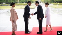 2023年5月19日,日本广岛举行的七国集团峰会开幕前,英国首相里希·苏纳克(左二)和他的妻子阿克沙塔·穆尔蒂(左一)在广岛和平纪念公园受到日本首相岸田文雄(右二)和妻子岸田裕子(右一)的欢迎。
