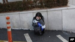 在韩国首尔的一家医院旁,一位粉丝在韩国已故歌手钟铉的葬礼上哭泣。(2017年12月21日)